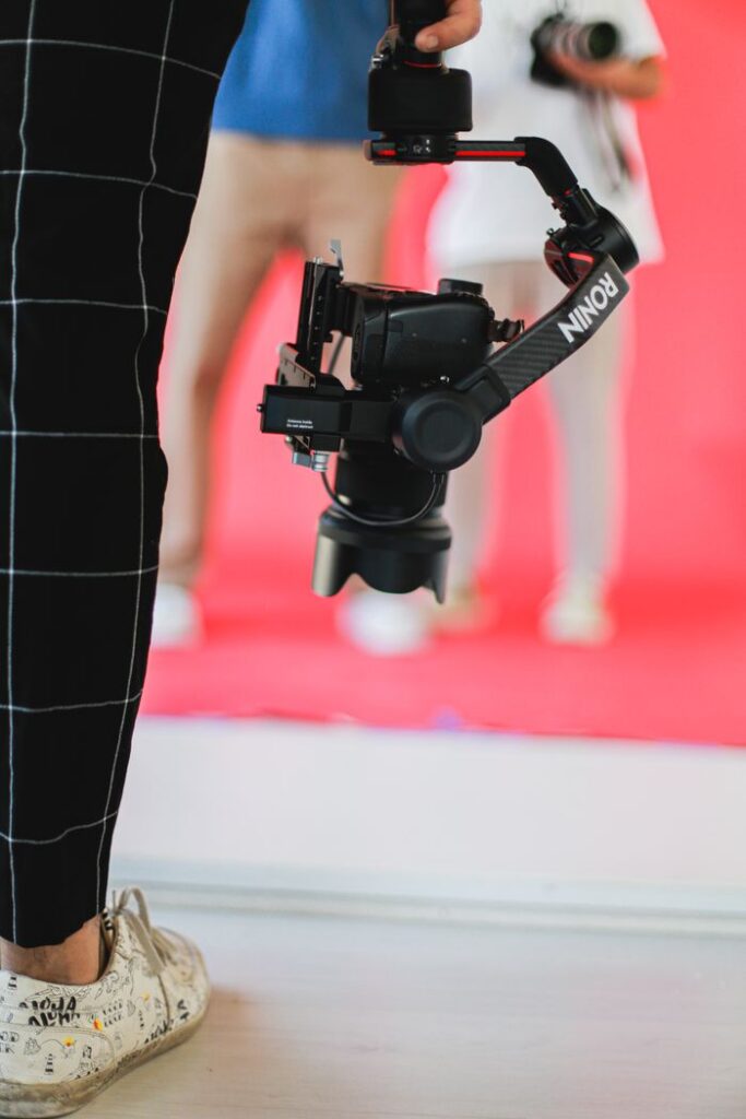 Close-up of a camera stabilizer during a filming session indoors with blurred background.